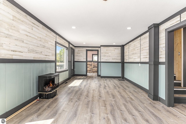 interior space with light wood-style floors, recessed lighting, and a wood stove