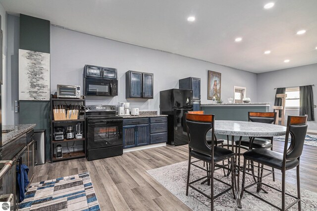 interior space with light wood-type flooring, a toaster, and recessed lighting