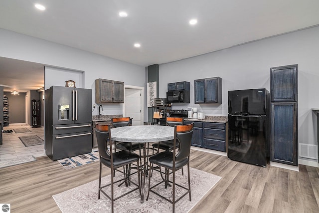 dining space with light wood-type flooring, visible vents, and recessed lighting