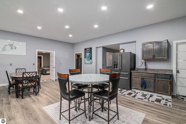 dining room with light wood-style floors, baseboards, and recessed lighting