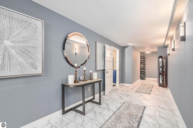 hall featuring marble finish floor and baseboards