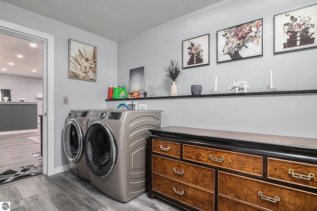 clothes washing area with recessed lighting, separate washer and dryer, wood finished floors, laundry area, and baseboards