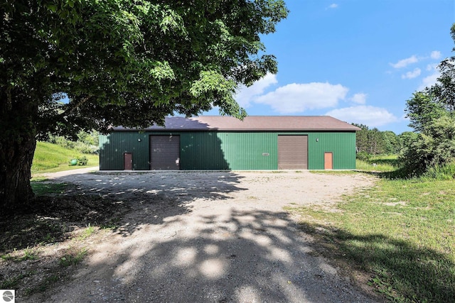view of front of home featuring a garage and an outbuilding