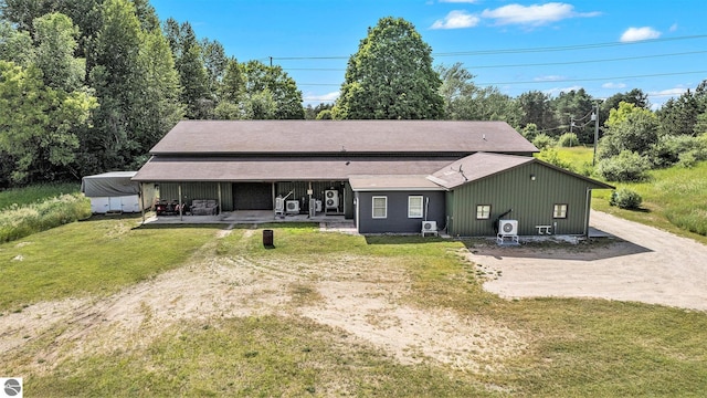 view of front of home with driveway, a patio area, and a front yard