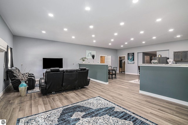 living area with light wood-style floors, baseboards, and recessed lighting