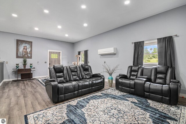 living room featuring recessed lighting, a wall mounted air conditioner, wood finished floors, and baseboards