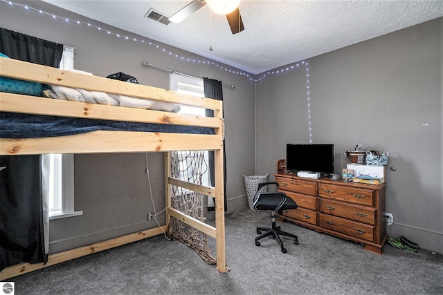 bedroom with a textured ceiling, ceiling fan, carpet, and visible vents