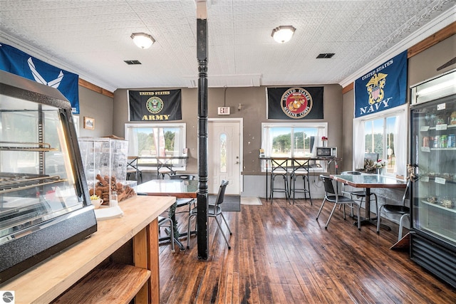 dining area featuring hardwood / wood-style floors, visible vents, and crown molding