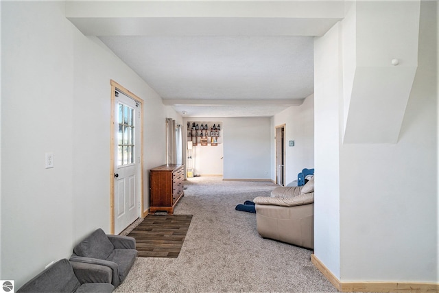 carpeted living area featuring baseboards