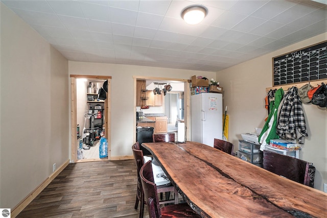 dining area featuring dark wood-style flooring and baseboards