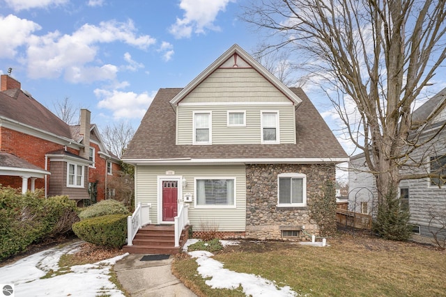 view of front facade featuring a shingled roof and stone siding