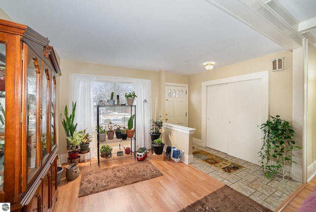 entrance foyer featuring visible vents, baseboards, and wood finished floors