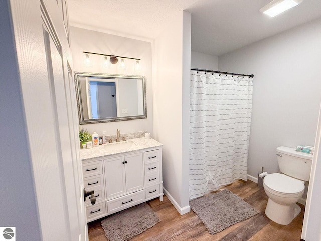 full bath with toilet, vanity, wood finished floors, a shower with curtain, and baseboards