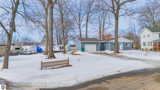 snowy yard with a residential view, fence, and an attached garage