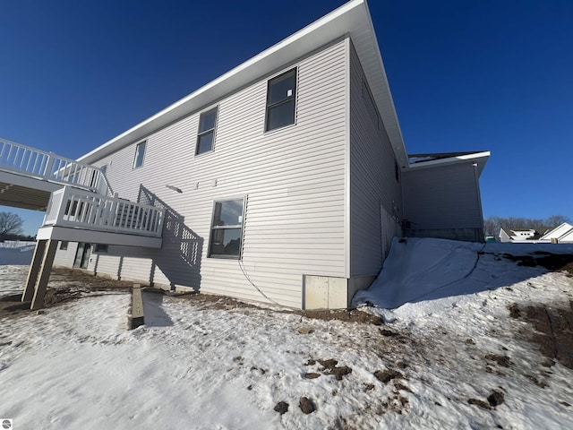 view of snow covered back of property