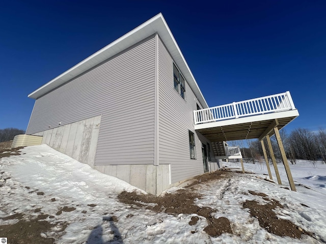 view of snow covered exterior with a deck