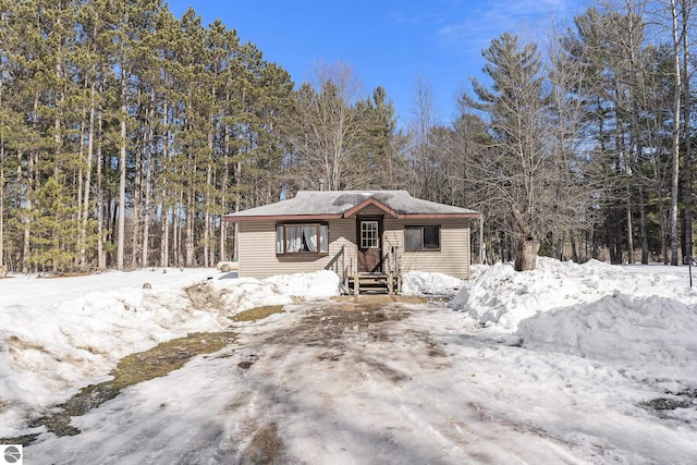 view of front of property featuring a view of trees