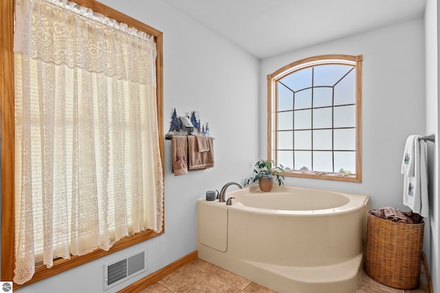 full bathroom featuring a garden tub, visible vents, and tile patterned floors