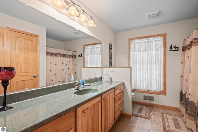 full bath featuring toilet, vanity, visible vents, and tile patterned floors