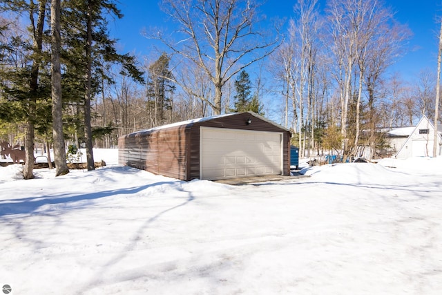 snow covered garage featuring a garage