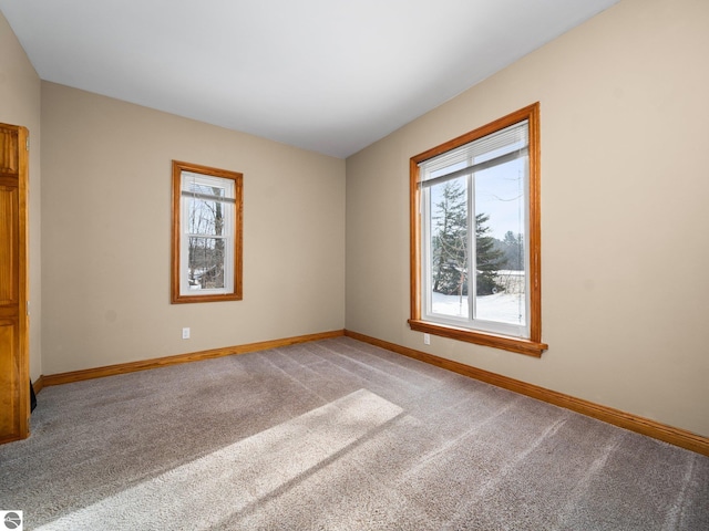 spare room with light colored carpet and baseboards