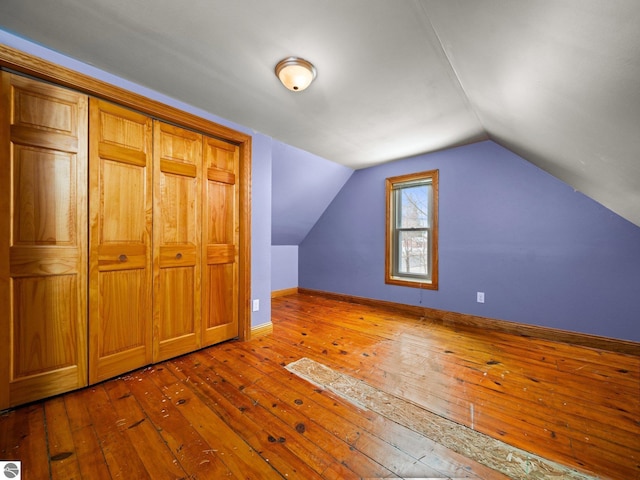 bonus room with lofted ceiling, hardwood / wood-style floors, and baseboards