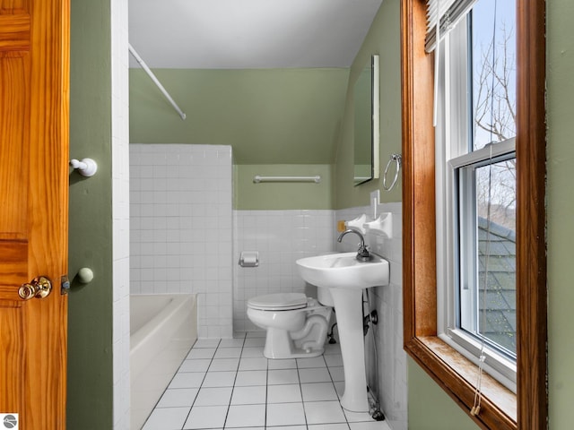 full bath featuring a bathtub, tile patterned flooring, toilet, and a healthy amount of sunlight