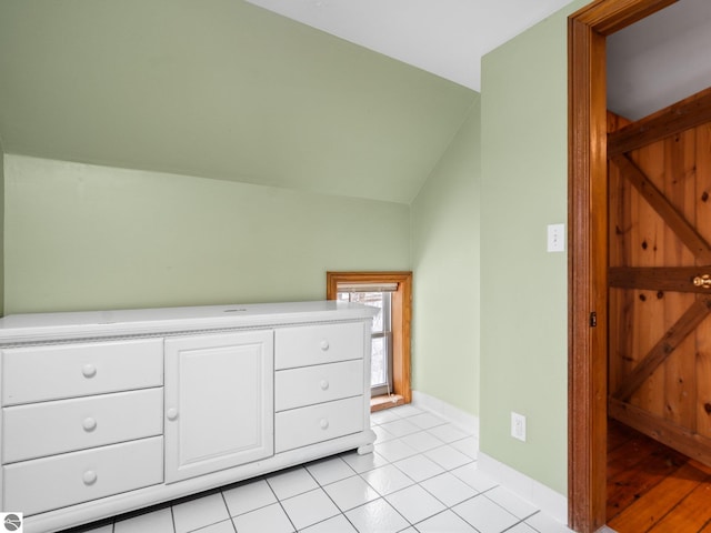 bonus room featuring light tile patterned floors, baseboards, and vaulted ceiling