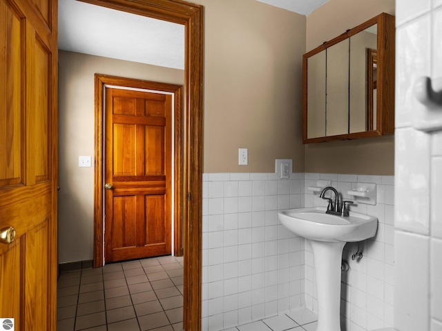 bathroom with a wainscoted wall, tile walls, and tile patterned floors