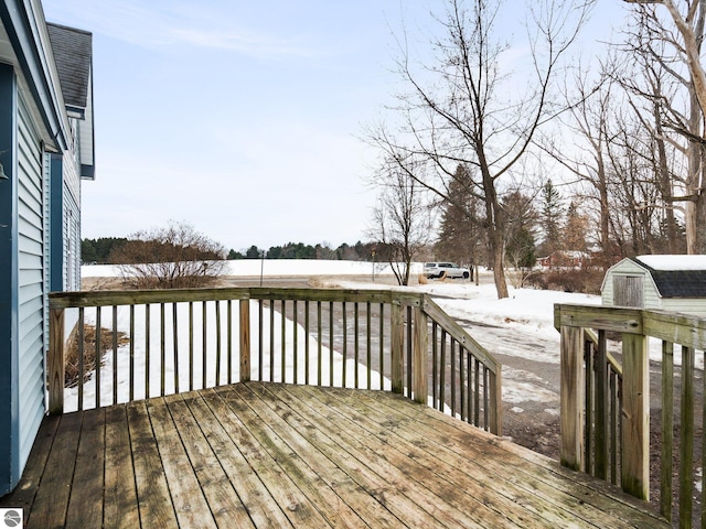 wooden deck featuring an outbuilding and a shed