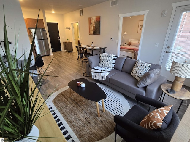 living area featuring light wood-type flooring and visible vents