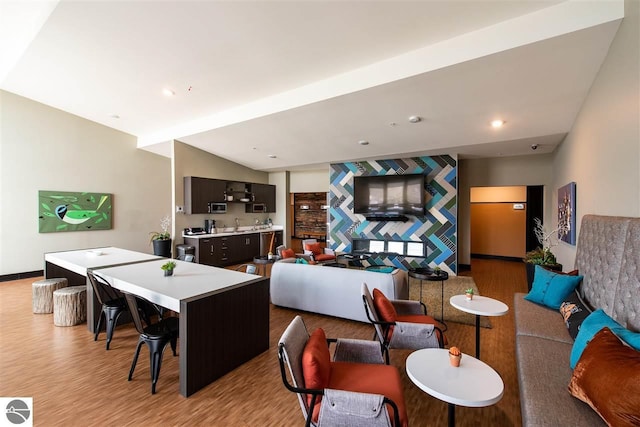 living area with vaulted ceiling, baseboards, light wood-style flooring, and recessed lighting