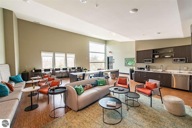 living room with high vaulted ceiling and light wood finished floors