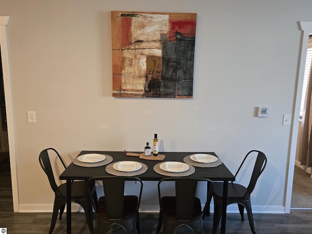 dining room featuring baseboards and dark wood finished floors