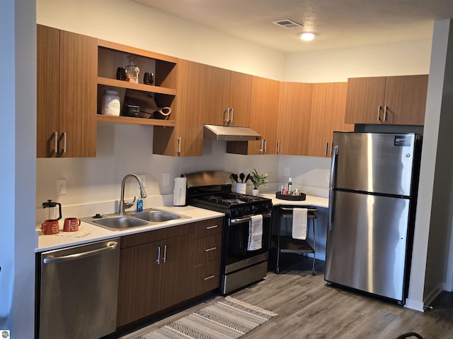 kitchen with visible vents, stainless steel appliances, light countertops, under cabinet range hood, and a sink