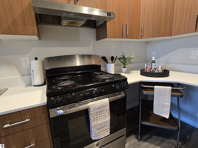 kitchen with modern cabinets, brown cabinets, light countertops, stainless steel range with electric stovetop, and exhaust hood