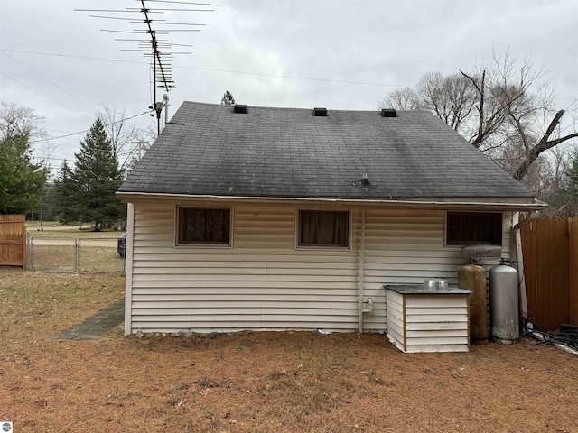 rear view of property featuring fence