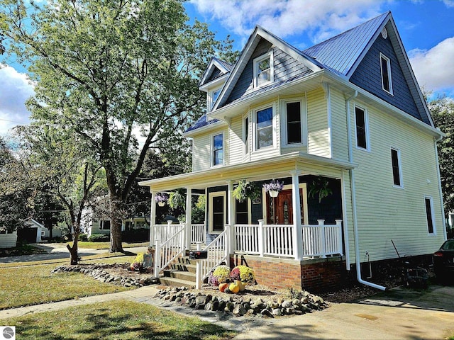 view of front of home featuring metal roof, a porch, and a standing seam roof