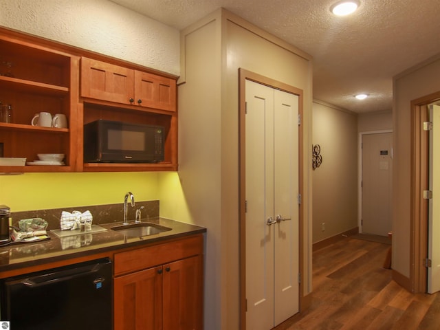 kitchen featuring a textured ceiling, dark wood-type flooring, a sink, black appliances, and dark countertops