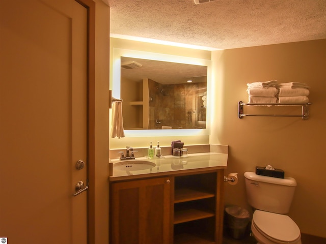 full bathroom with visible vents, toilet, a textured ceiling, vanity, and tiled shower