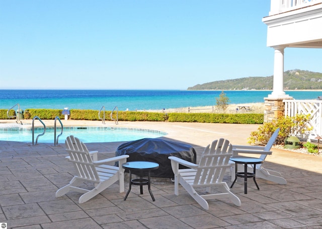 view of patio featuring a water view and an outdoor pool