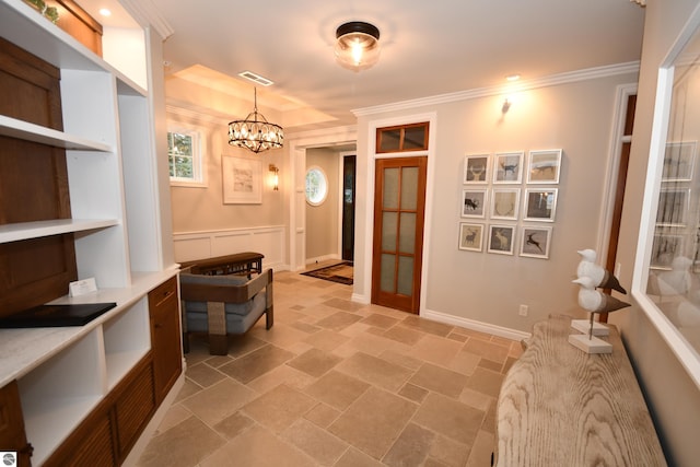 interior space featuring a notable chandelier, visible vents, baseboards, ornamental molding, and stone finish floor