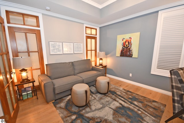 living room with ornamental molding, wood finished floors, and baseboards