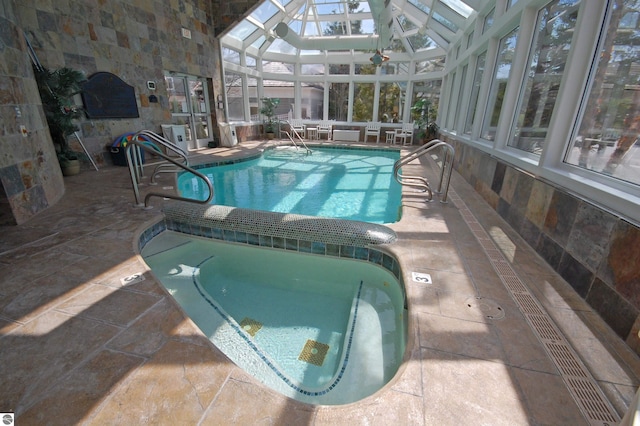 community pool featuring an indoor hot tub, a patio area, and a lanai