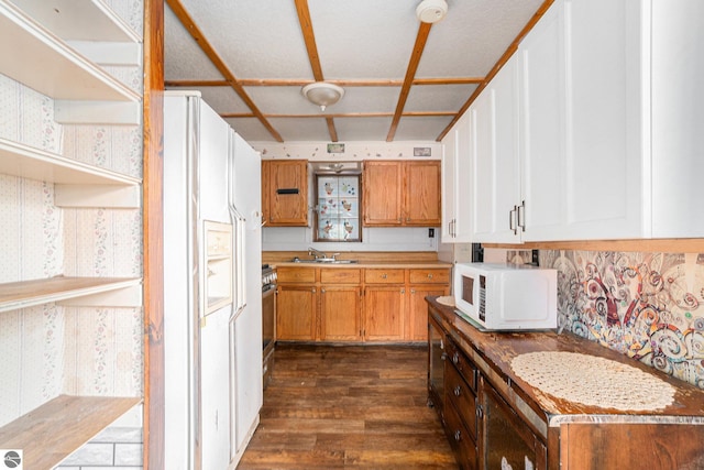 kitchen with white appliances, dark wood-type flooring, a sink, brown cabinets, and open shelves