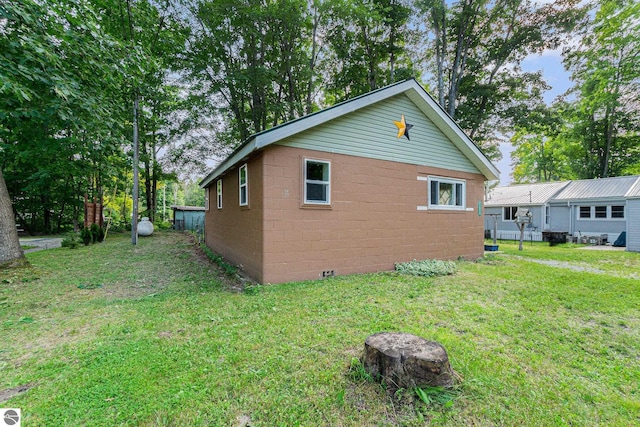 view of home's exterior featuring a lawn and concrete block siding