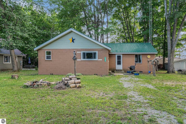 back of property with entry steps, crawl space, concrete block siding, and a lawn