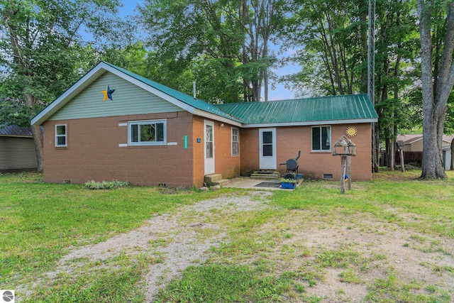 back of house featuring entry steps, driveway, crawl space, and a lawn