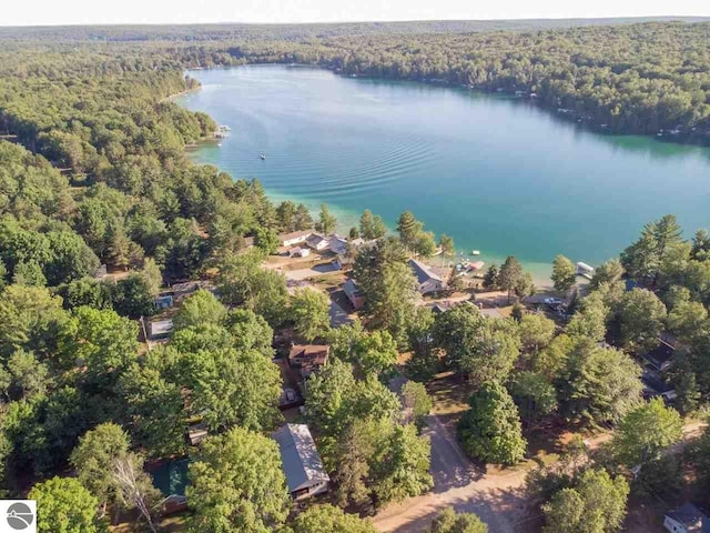 drone / aerial view featuring a water view and a wooded view