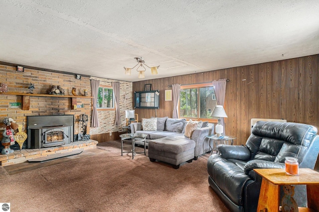 carpeted living room featuring a healthy amount of sunlight, wood walls, and a textured ceiling